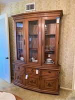 Full front view of Thomasville china hutch showing glass doors with diamond pattern center door and the lower drawers and cabinets.