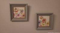 Two framed floral watercolor paintings hung side by side on a wall, showing overall size and appearance.