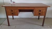 Front view of desk showing top surface, drawer configuration, and legs
