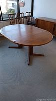 Full view of oval teak dining table with two pedestal bases