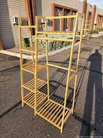 Full view of the bamboo garment rack showing the hanging bar and side shelves in natural bamboo finish.