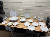 Full lot arrangement on table showing all dishes, plates, cups, and decorative small plates.
