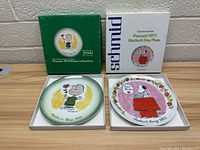 Two Schmid Peanuts Mother's Day plates in original boxes on a table showing both 1971 and 1972 editions.