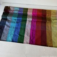 Silk panel laid out showing smooth texture and multi-colored vertical stripes, each stripe in distinct color tones.