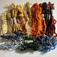 Multiple skeins of tapestry wool yarn in various colors showing palette and quantity
