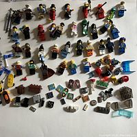 Flat layout of minifigures and small accessories on white background