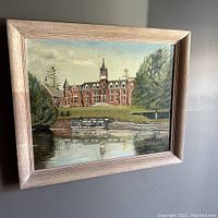Framed oil painting showing the McGreer building and principal's residence of Bishop's University reflecting in a pond or lake.