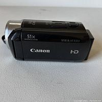 Side view of black Canon VIXIA HF300 HD camcorder showing 51x advanced zoom, Canon and HD logos