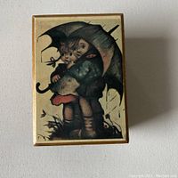 Top view showing music box illustration of two children under an umbrella
