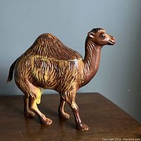 Side profile showing detailed plastic camel figurine with textured fur and painted features.