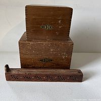 Photo showing two wooden boxes labeled INDEX and a carved wooden incense holder with flip lid on a white surface.