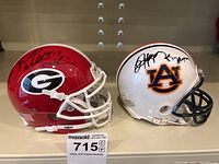 Front view of both mini helmets side by side showing team colors and signatures