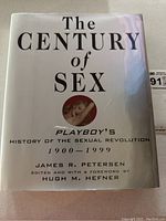 Front view of book dust jacket showing title 'The Century of Sex: Playboy's History of the Sexual Revolution 1900-1999' by James R. Petersen edited with foreword by Hugh M. Hefner