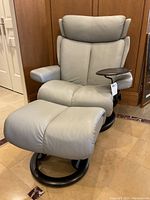 Full view of pale grey Ekornes recliner chair and matching ottoman from front angle