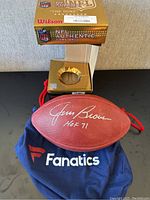 Overall view of signed football on Fanatics bag with original Wilson box behind