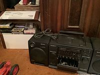 Sony CFD-440 boom box with power cord placed near box of cassette tapes.