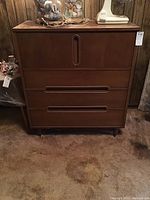 Front view of closed chest showing two drawers below and cabinet doors above