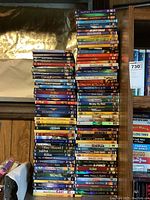 Three vertical stacks of DVD cases on wooden shelving