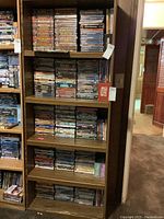 Five shelves of DVDs on wooden shelving unit