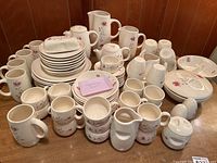 Overview of entire Duet pattern set showing plates, mugs and serving pieces arranged on table.
