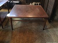 Front angle view of square table showing inlay and tapered legs