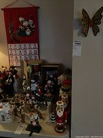 Wide view showing multiple nutcracker figurines, snowmen figures, and reindeer on a table under fabric advent calendar