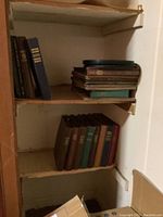 Multiple vintage albums with 78 RPM records on shelves, varying in color and size