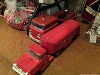 Both red vintage Texaco trucks placed on carpet showing fire truck and tanker truck in one frame.