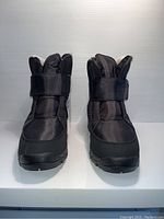 Front view of the black Ciabatta's boots showing the synthetic material and velcro strap closure.