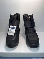 Front view of two black Ciabatta's winter boots with tag attached, showing Velcro strap closure.