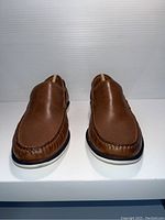 Front view of brand new brown leather Clarks men's shoes, showing the stitched upper and white sole.