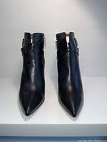 Front view of the pair of Donald Pliner black leather ankle boots with pointed toes