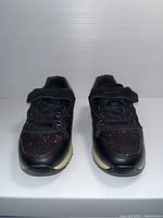 Front view of the pair of black and pink Geox kids shoes with lace and velcro strap.