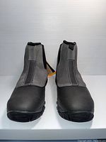 Front view of a pair of black and grey Hi-Tec men's shoes, showing toe and front panels with stitching details and rugged sole.