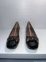 Front view of the pair of leopard print Naturalizer ladies shoes with black patent toe and bow detail, size 11