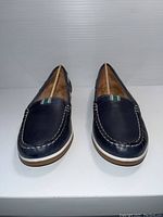 Front view of the navy blue Naturalizer ladies shoes showing the white stitching and fabric stripe detail.