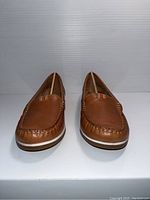 Front view of the Naturalizer brown shoes showing the stitched design and leather texture.