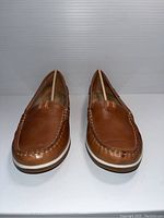 Front view of brown leather moccasin shoes showing toe and stitching details