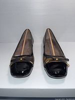 Front view showing black patent toe with bow detail on leopard print shoe body