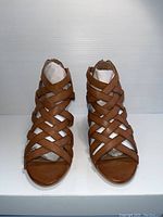 Front view of the brown leather strappy heeled sandals showing the criss-cross straps and open toe design.