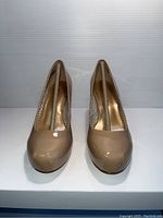 Front view of the nude patent leather high heel shoes showing glossy finish and rounded toe.