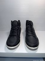 Front view of the pair of black Steve Madden high-top shoes with white sole.