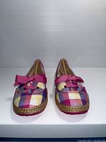 Front view of the UGG kids shoes showing plaid pattern and pink bow