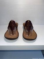 Front view of UGG brown leather women's sandals size 7 showing thong strap design and tan footbed