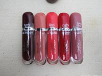 Five tubes of Revlon Ultra HD Vinyl Lip Polish in different shades lined up.