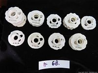 Top view of all 15 Singer sewing machine stitch pattern discs arranged on black cloth showing different pattern numbers and designs.
