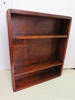 Front view of vintage dark wood shelf.