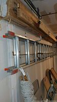 Full view of the metal extension ladder hanging horizontally showing the length and construction details.