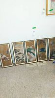 Five framed Asian wall art pieces placed on floor, showing overall set and framing condition.