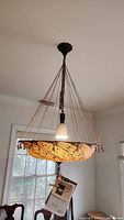 View of entire suspended Fortuny Lamps chandelier from beneath showing fabric shade, hanging cords and tassel.